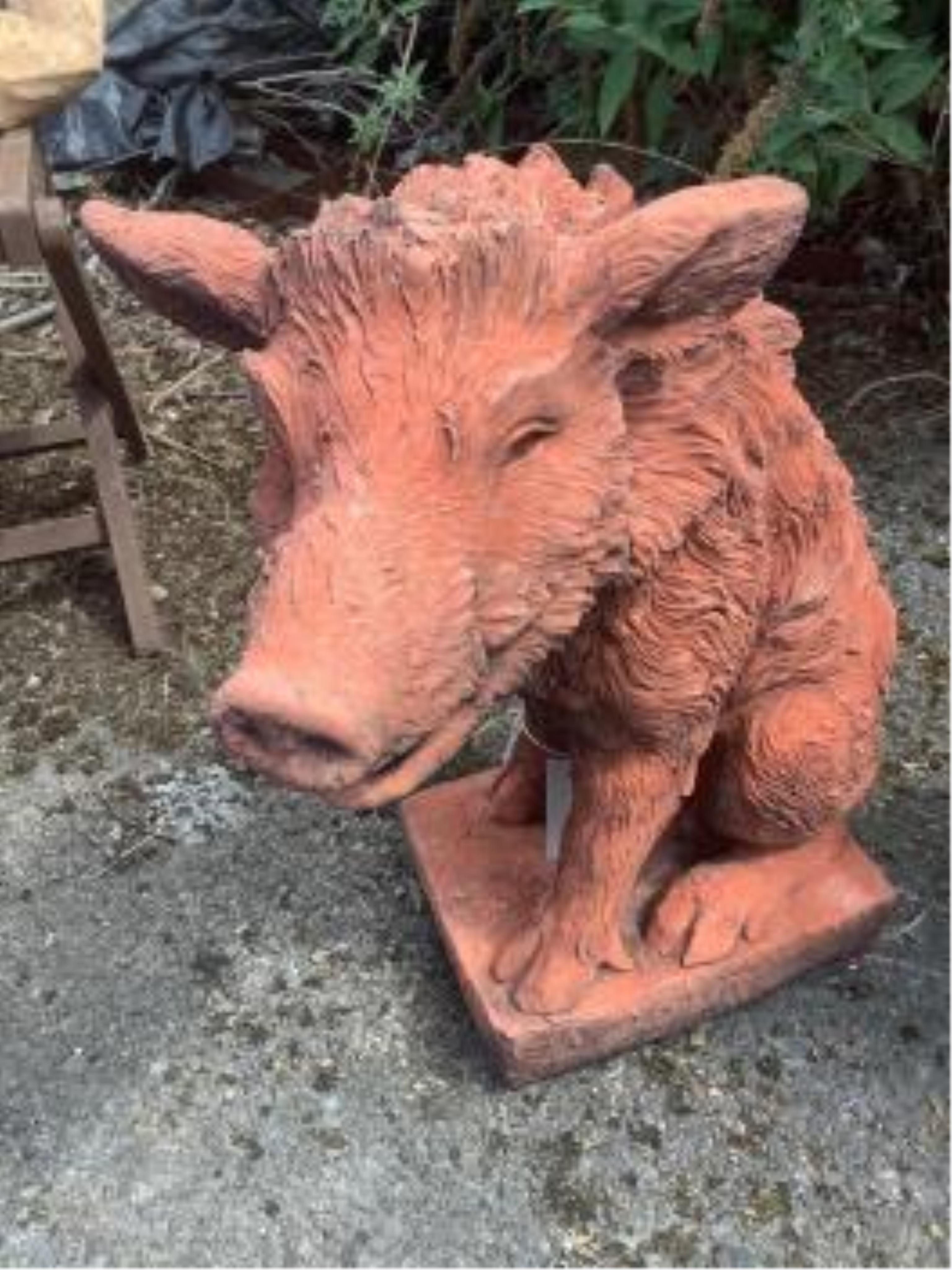 A pair of terracotta seated wild boar garden ornaments